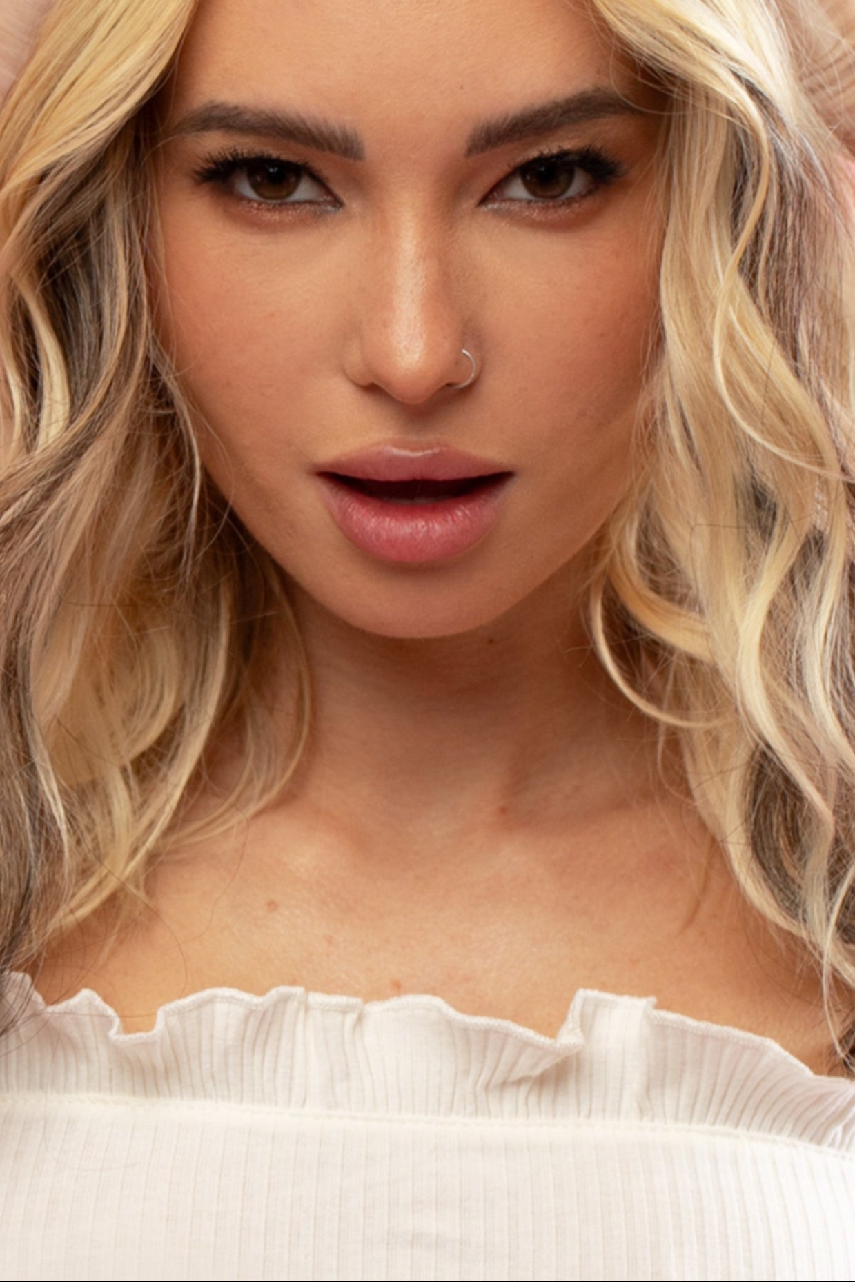 קלוז אפ של בחורה שבשיער שלה שזורים גווני שיער טבעיים, גליים - בצבע חום כהה - תוספות השיער מיועדות לחיבור עצמאי, פשוט  וקבוע לשיער או לחיבור זמני - Shufizoo לשיער