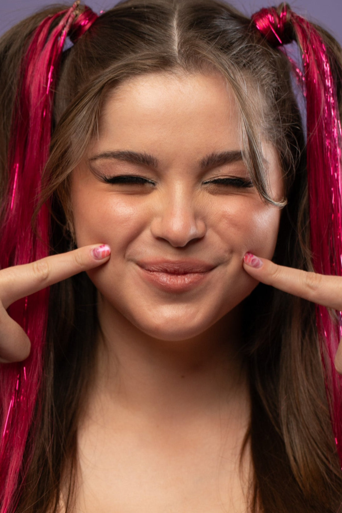 קלוז אפ של בחורה עם קוקיות, שבשיער שלה שזורים גווני שיער טבעיים, חלקים- בצבע פוקסיה- תוספות השיער מיועדות לחיבור עצמאי, פשוט  וקבוע לשיער או לחיבור זמני לשיער  - Shufizoo