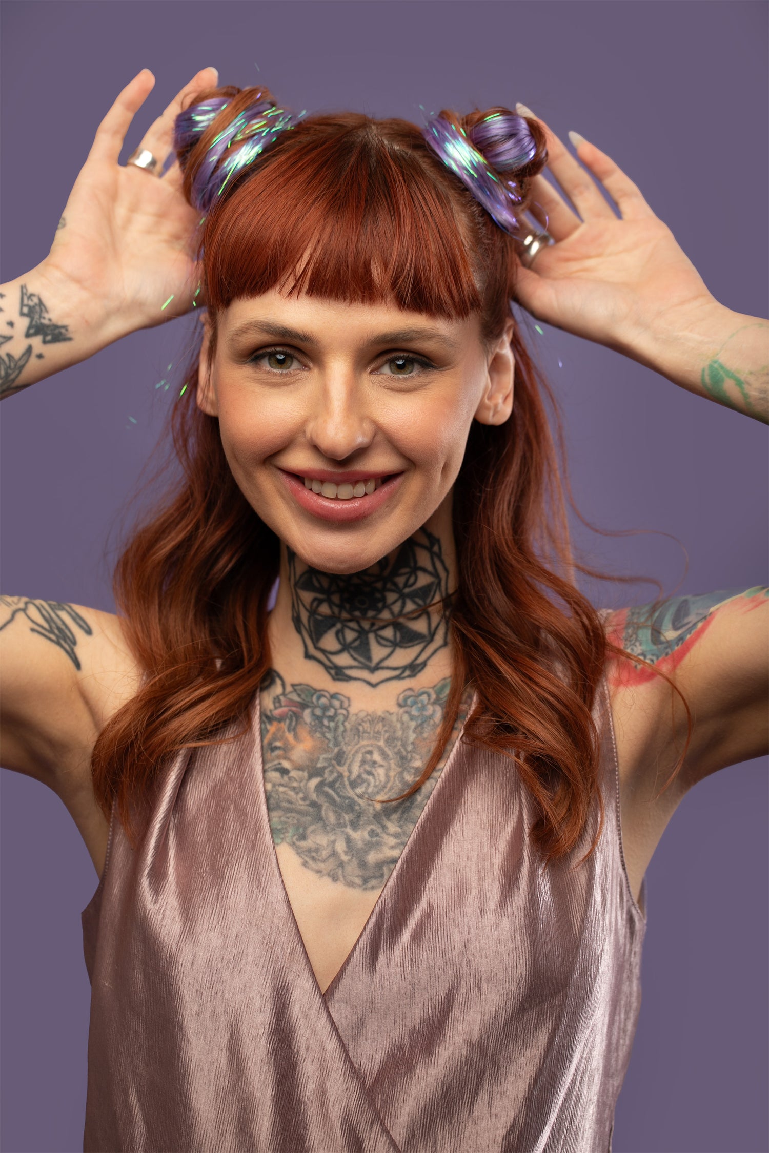 מדיום שוט של בחורה עם 2 גולגולים, שבשיער שלה שזורים גווני שיער טבעיים, חלקים - בצבע סגול לילך - תוספות השיער מעורבבות עם גווני פיות זוהרים ומיועדות לחיבור עצמאי, פשוט  וקבוע לשיער או לחיבור זמני לשיער  - Shufizoo