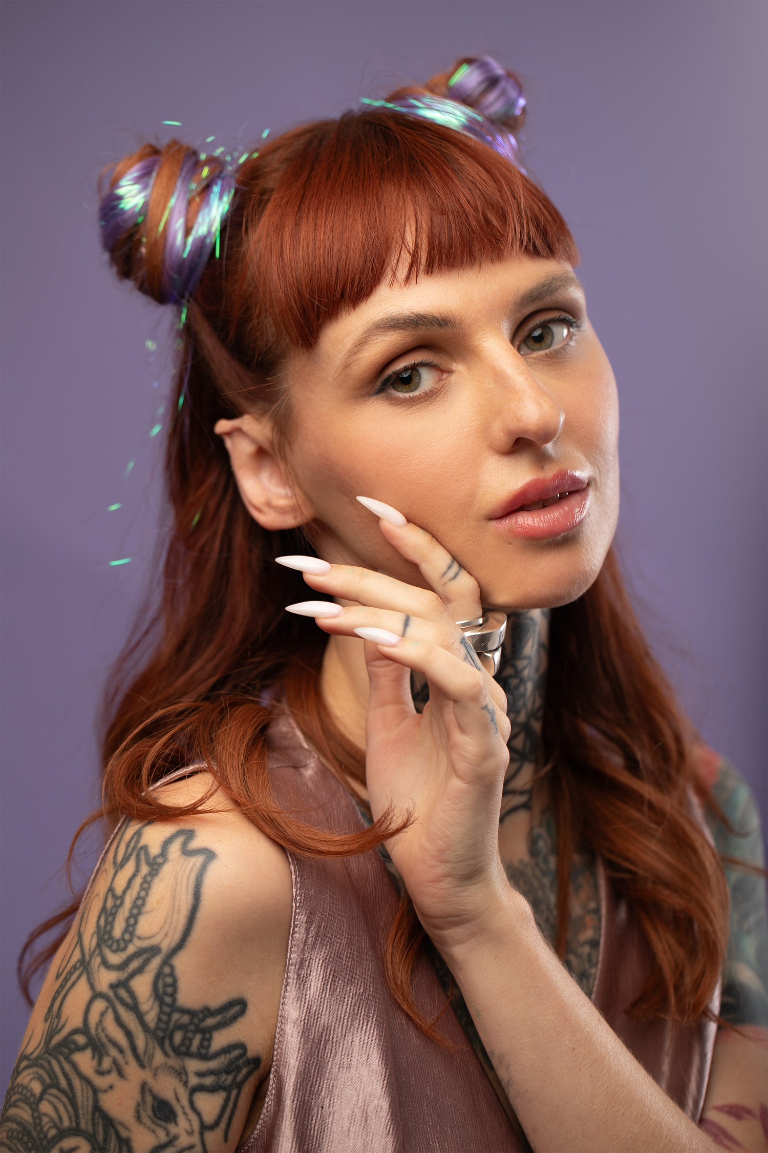 מדיום שוט של בחורה עם 2 גולגולים, שבשיער שלה שזורים גווני שיער טבעיים, חלקים - בצבע סגול לילך - תוספות השיער מעורבבות עם גווני פיות זוהרים ומיועדות לחיבור עצמאי, פשוט  וקבוע לשיער או לחיבור זמני לשיער  - Shufizoo