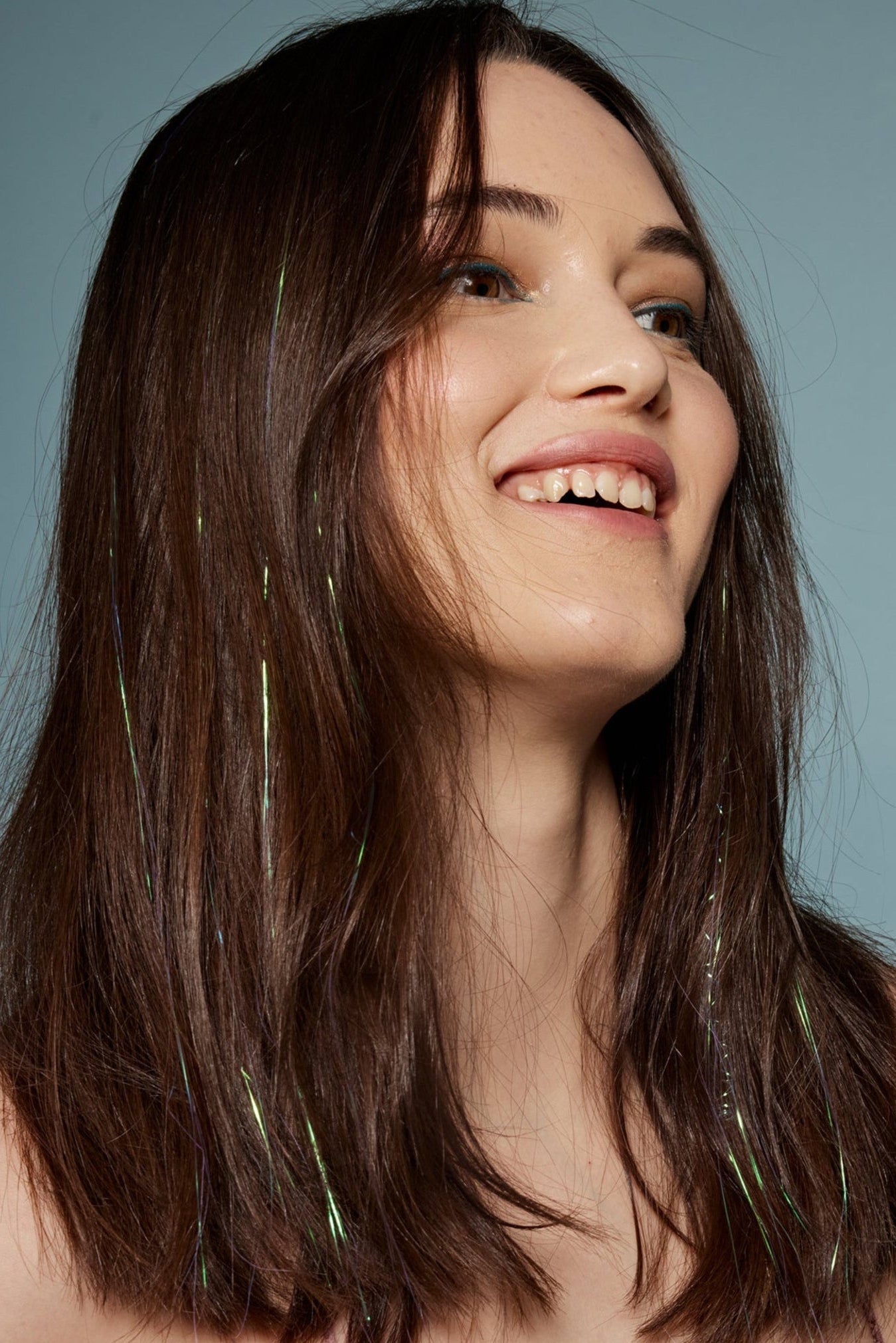 קלוז אפ של בחורה שבשיער שלה שזורים חוטי טינסל בצבעי לבן זוהר - הנקראים אצלנו גווני פיות. מיועדים לחיבור עצמאי, פשוט וקבוע לשיער או לחיבור זמני - Shufizoo