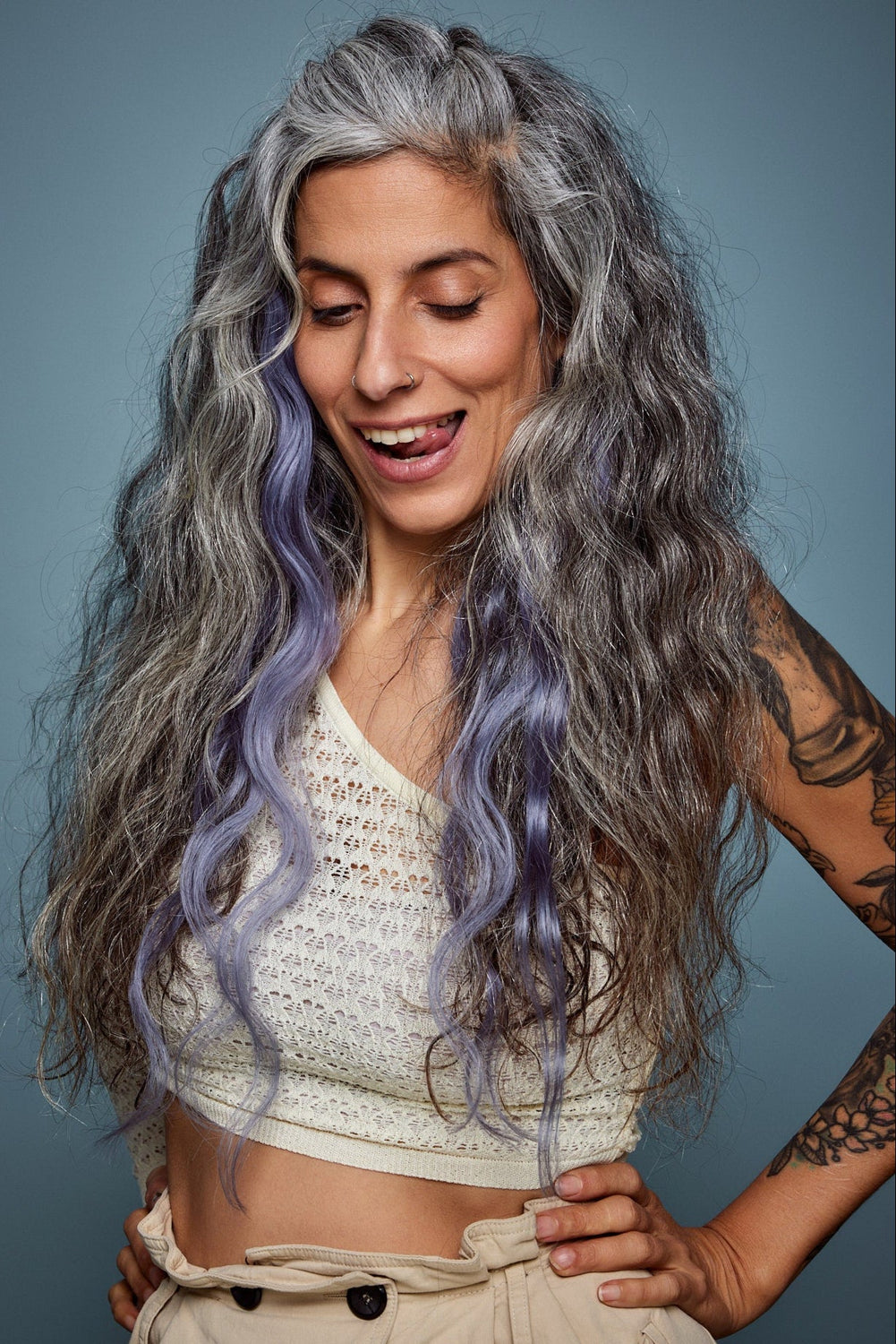 מדיום שוט של בחורה שבשיער שלה שזורים גווני שיער טבעיים, גליים - בצבע כחול אפור כהה  - תוספות השיער מיועדות לחיבור עצמאי, פשוט  וקבוע לשיער או לחיבור זמני לשיער  - Shufizoo 