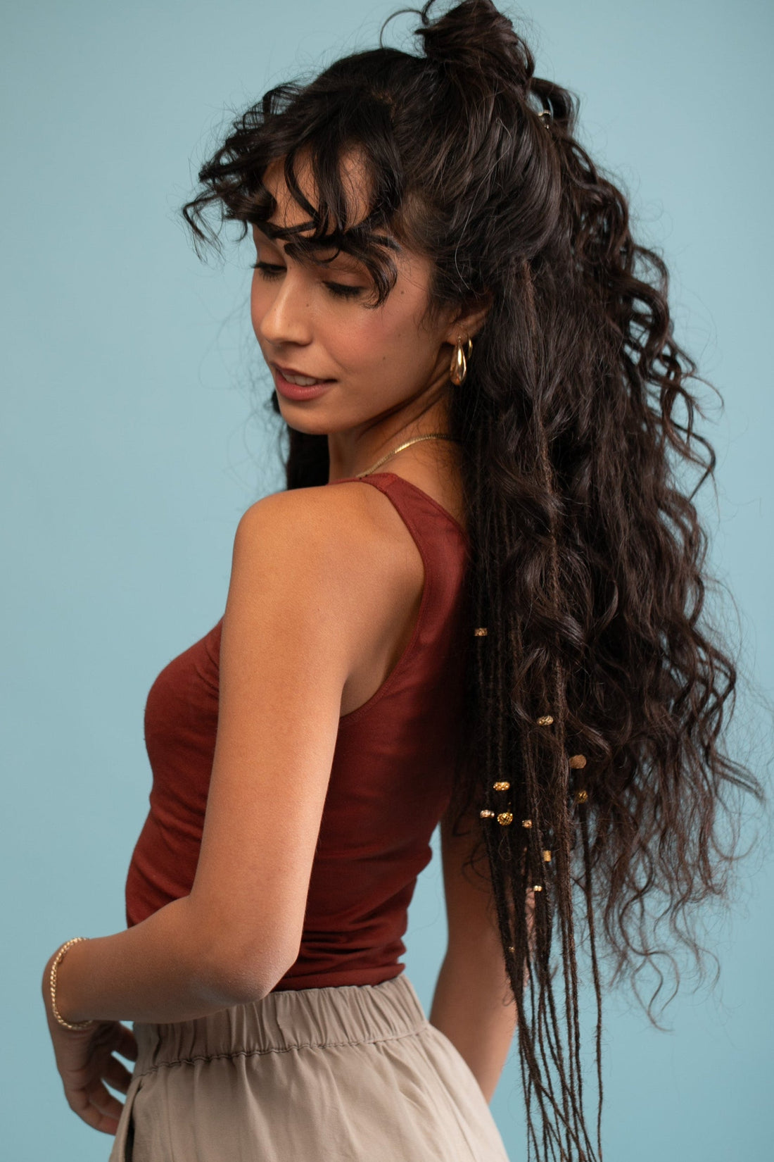 בחורה עם שיער חום כהה שעל הראש שזורות לה ראסטות סינטטיות שזורות תכשיטים בצבע חום כהה - shufizoo